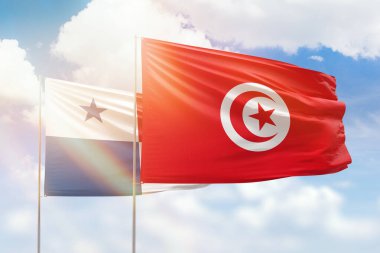 Sunny blue sky and flags of tunisia and panama