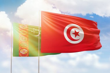 Sunny blue sky and flags of tunisia and turkmenistan