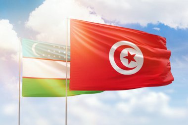 Sunny blue sky and flags of tunisia and uzbekistan