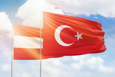 Sunny blue sky and flags of turkey and austria