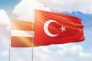 Sunny blue sky and flags of turkey and latvia