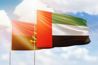 Sunny blue sky and flags of united arab emirates and angola