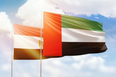 Sunny blue sky and flags of united arab emirates and egypt