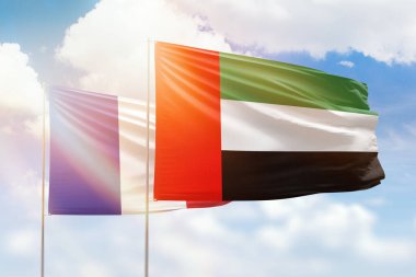 Sunny blue sky and flags of united arab emirates and france