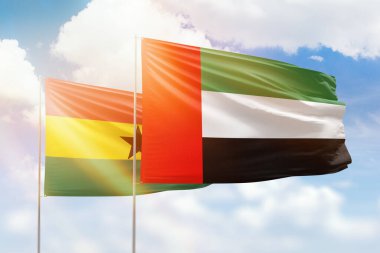 Sunny blue sky and flags of united arab emirates and ghana