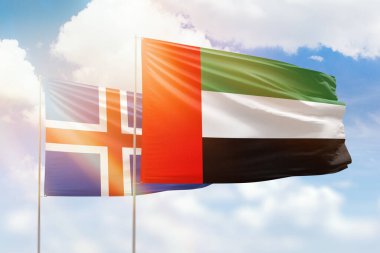Sunny blue sky and flags of united arab emirates and iceland