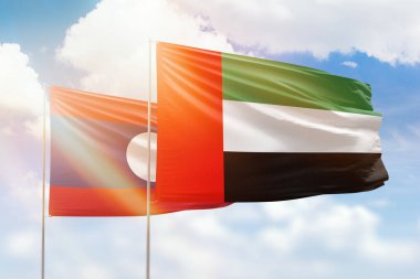 Sunny blue sky and flags of united arab emirates and laos