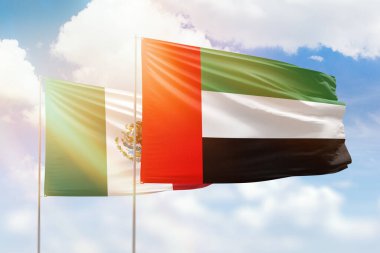 Sunny blue sky and flags of united arab emirates and mexico