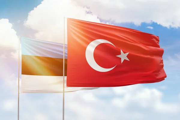 Sunny blue sky and flags of turkey and estonia