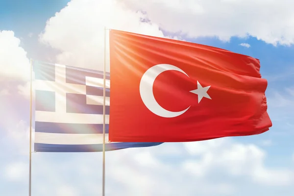 Sunny blue sky and flags of turkey and greece