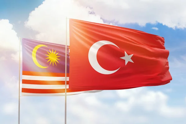 Sunny blue sky and flags of turkey and malaysia