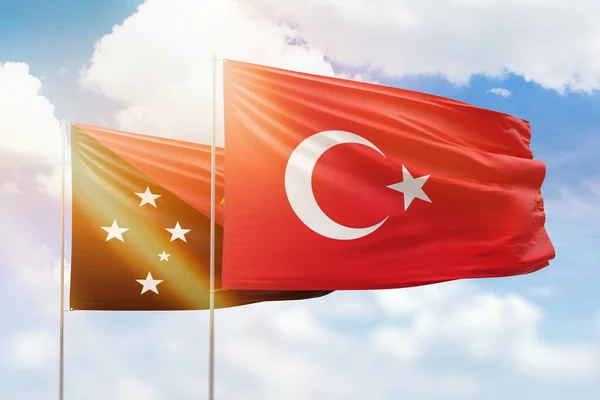 Sunny blue sky and flags of turkey and papua new guinea