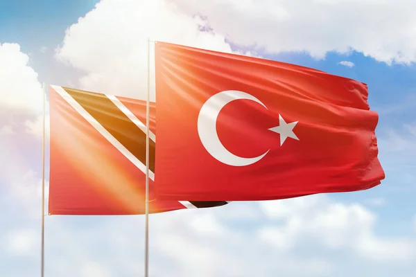 Sunny blue sky and flags of turkey and trinidad and tobago