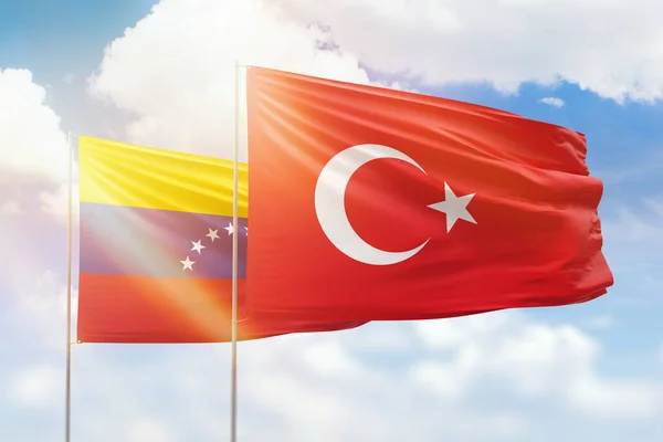 Sunny blue sky and flags of turkey and venezuela
