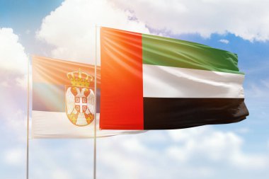 Sunny blue sky and flags of united arab emirates and serbia