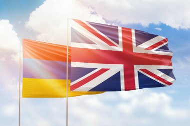 Sunny blue sky and flags of united kingdom and armenia