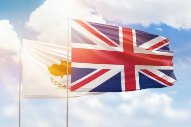 Sunny blue sky and flags of united kingdom and cyprus