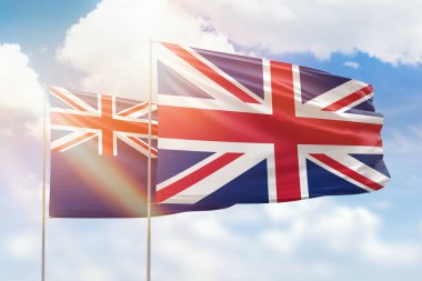 Sunny blue sky and flags of united kingdom and new zealand