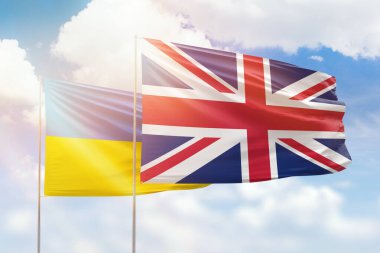 Sunny blue sky and flags of united kingdom and ukraine