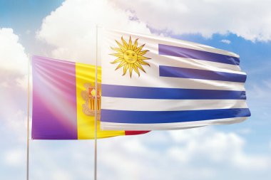 Sunny blue sky and flags of uruguay and andorra