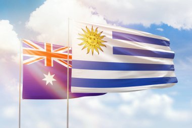 Sunny blue sky and flags of uruguay and australia