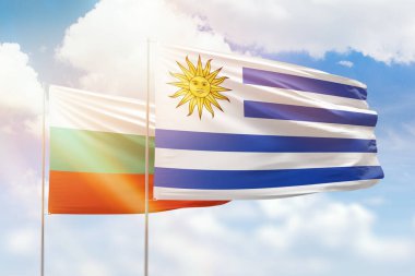 Sunny blue sky and flags of uruguay and bulgaria