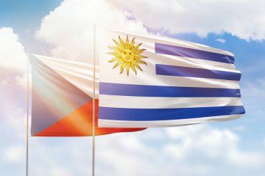 Sunny blue sky and flags of uruguay and czechia