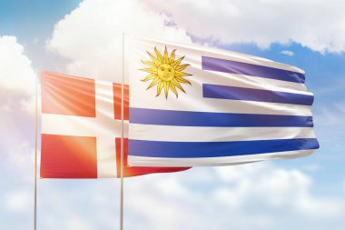 Sunny blue sky and flags of uruguay and denmark