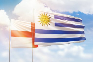 Sunny blue sky and flags of uruguay and england