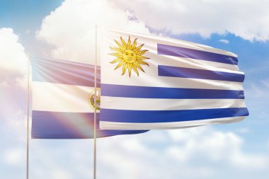 Sunny blue sky and flags of uruguay and el salvador