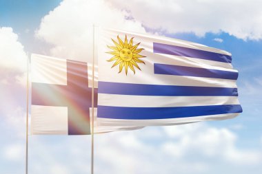 Sunny blue sky and flags of uruguay and finland