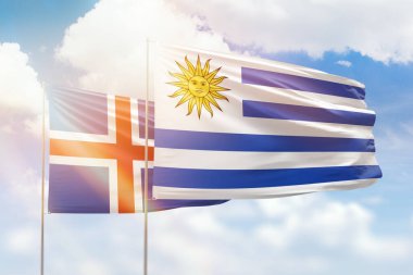 Sunny blue sky and flags of uruguay and iceland