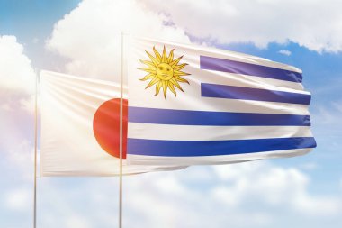 Sunny blue sky and flags of uruguay and japan