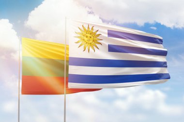 Sunny blue sky and flags of uruguay and lithuania