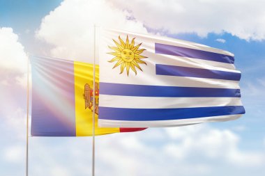 Sunny blue sky and flags of uruguay and moldova