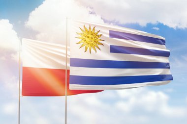Sunny blue sky and flags of uruguay and poland