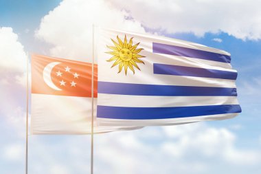 Sunny blue sky and flags of uruguay and singapore