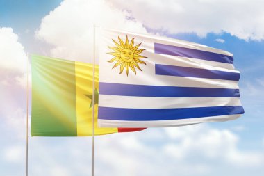 Sunny blue sky and flags of uruguay and senegal