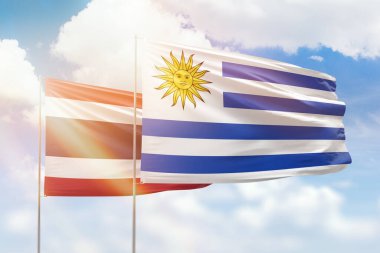 Sunny blue sky and flags of uruguay and thailand