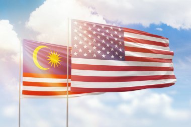 Sunny blue sky and flags of united states of america and malaysia