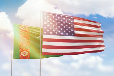 Sunny blue sky and flags of united states of america and turkmenistan