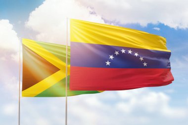 Sunny blue sky and flags of venezuela and jamaica
