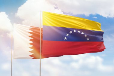 Sunny blue sky and flags of venezuela and qatar