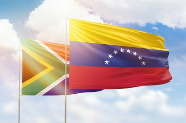 Sunny blue sky and flags of venezuela and south africa