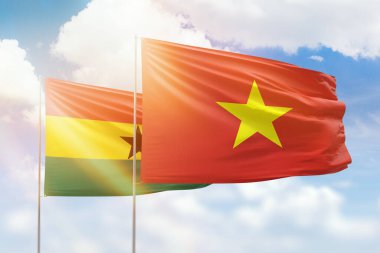 Sunny blue sky and flags of vietnam and ghana