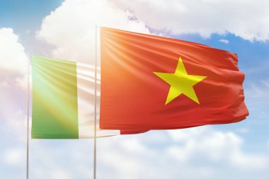 Sunny blue sky and flags of vietnam and italy