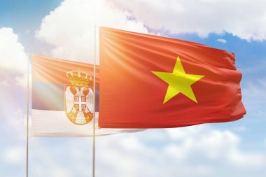 Sunny blue sky and flags of vietnam and serbia