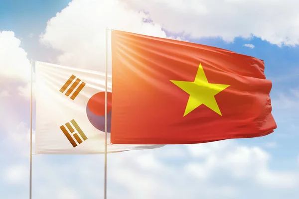 Sunny blue sky and flags of vietnam and south korea