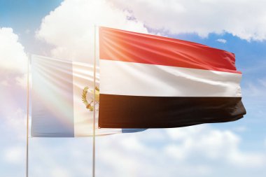 Sunny blue sky and flags of yemen and guatemala