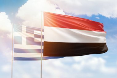 Sunny blue sky and flags of yemen and greece